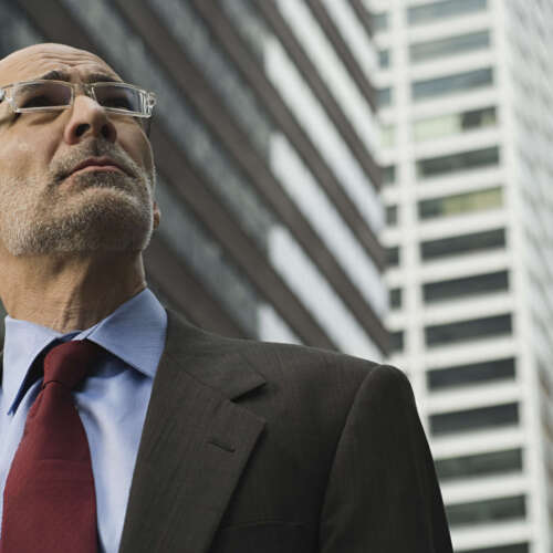 Businessman looking ahead with an ambitious gaze against an urban backdrop.