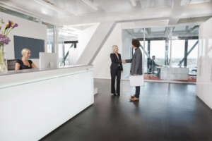 Woman shaking hands with visitor at reception